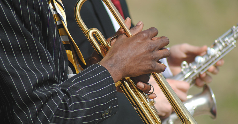 Detaljbild på två män som spelar trumpet och saxofon