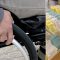 En person i rullstol och en hylla för valsedlar vid ett svenskt val