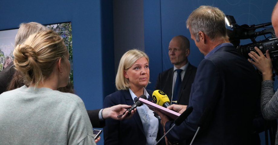 Finansminister Magdalena Andersson svarar på frågor från journalister som står runt henne och räcker fram sina mikrofoner. På presskonferensen om höstbudgeten.